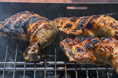 Some chicken thighs on a barbecue.