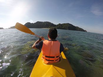 Rear view of man on sea against sky