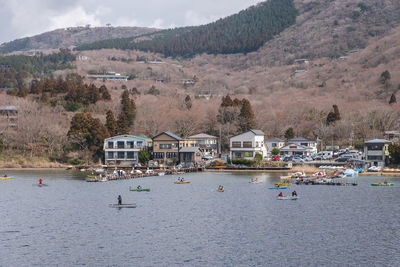 Scenic view of lake by buildings against mountain