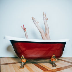 Low section of woman relaxing on bathtub