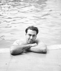 High angle portrait of young man relaxing in swimming pool