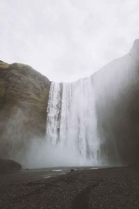 Scenic view of waterfall against sky