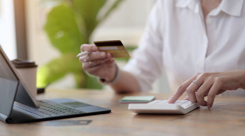 Midsection of man using laptop on table