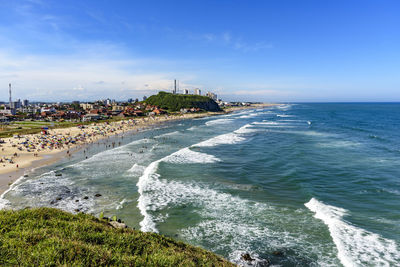 Crowded beach and the city on a beautiful day intorres city, rio grande do sul state, brazil