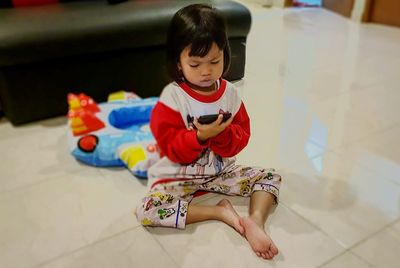 High angle view of baby boy sitting on floor at home