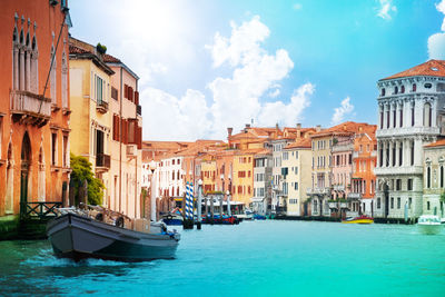 Boats in canal amidst buildings in city