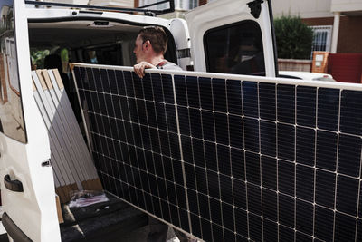 Technician unloading solar panels from van