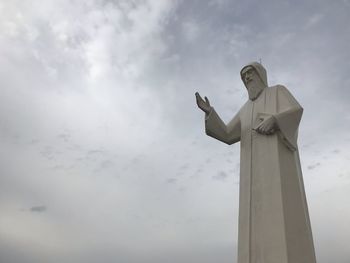 Low angle view of jesus christ against sky