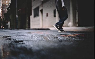 Low section of man skateboarding on road