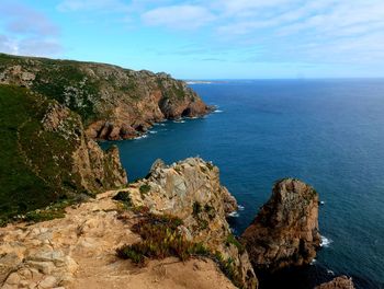 Rock formations by sea against sky