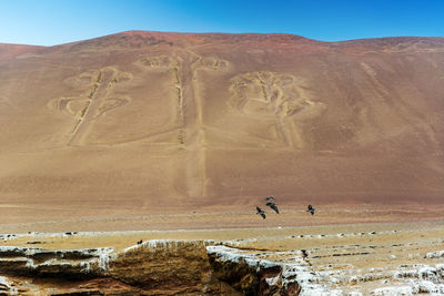 Scenic view of sand dunes against clear sky