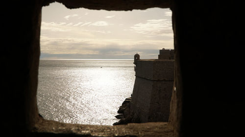 Scenic view of sea against sky seen through window