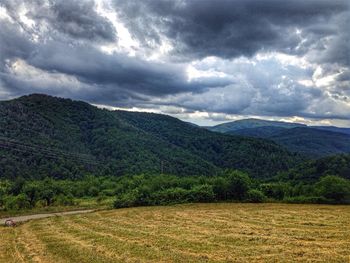 Scenic view of landscape against storm clouds