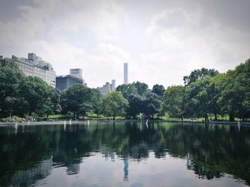 Scenic view of lake by buildings against sky