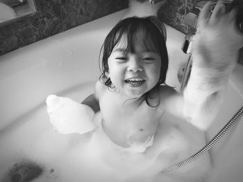 Portrait of shirtless cheerful girl in bathtub
