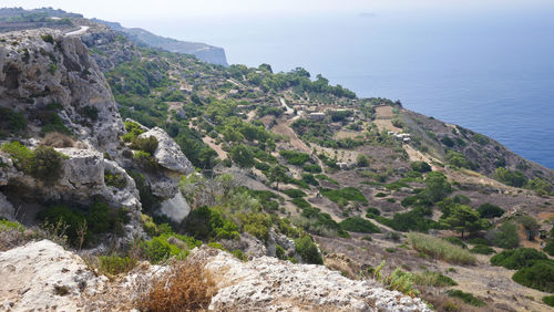 Scenic view of rocky mountain by sea against sky