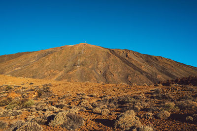 Scenic view of rocky mountains against clear blue sky