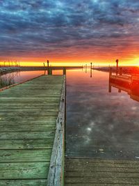 Pier over sea against sky during sunset