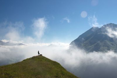 Man standing on mountain against sky