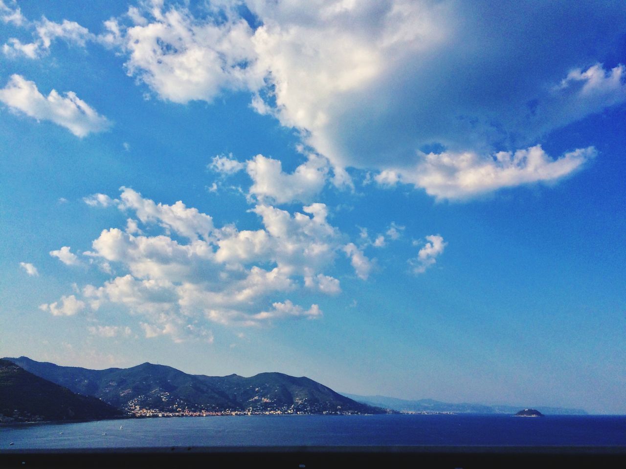 water, sea, mountain, sky, scenics, tranquil scene, tranquility, beauty in nature, waterfront, mountain range, cloud - sky, nature, blue, cloud, idyllic, outdoors, beach, day, cloudy, coastline