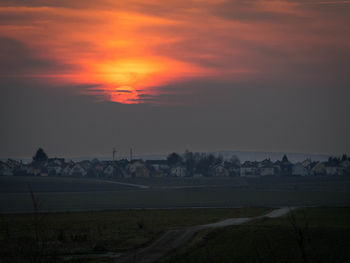 Scenic view of field against orange sky