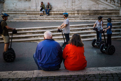 Rear view of men sitting in city