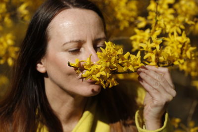 Close-up of young woman holding yellow flower