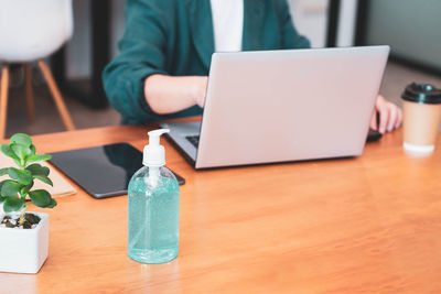 A bottle of alcohol gel on work table in office new normal to prevent covid 19 infection due covid.