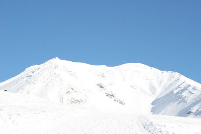 Scenic view of snowcapped mountains against clear blue sky