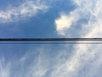 Low angle view of power lines against sky