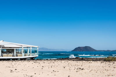 Scenic view of beach against clear blue sky