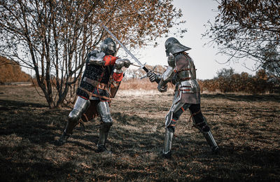 Full length of warriors fighting on field