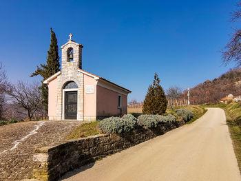 Church by building against clear blue sky