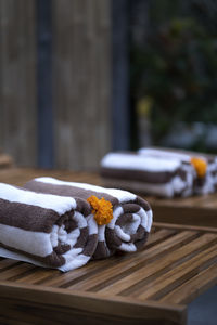 Rolled up towel close up on sunbeds with flowers