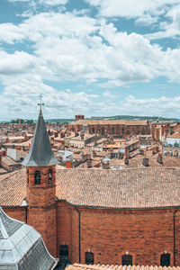 Buildings in city against cloudy sky