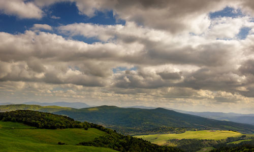 Scenic view of field against cloudy sky