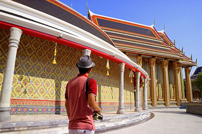 Visitor walking along the circular gallery of wat ratchabophit buddhist temple, bangkok, thailand