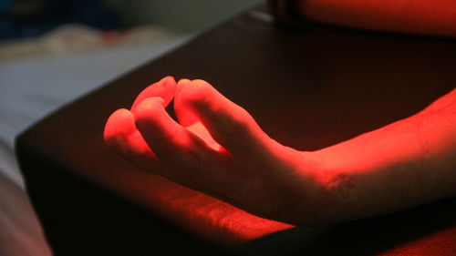 Close-up of hand on red table