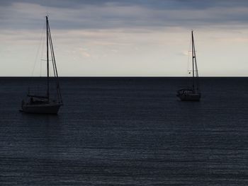 Sailboat sailing on sea against sky during sunset