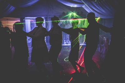 Group of people dancing in nightclub during party