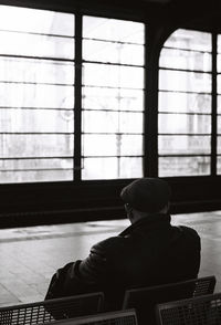 Rear view of man sitting at home