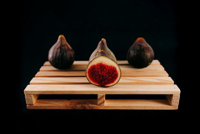 Close-up of fruits on table against black background