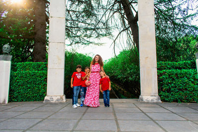 Portrait of mother with sons standing on footpath in park
