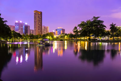 Reflection of buildings in lake at night