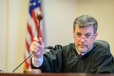 Close-up of judge banging gavel in courtroom