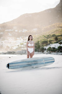 Full length of woman relaxing on land against sky