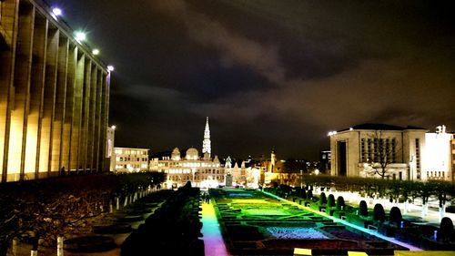 View of illuminated city against cloudy sky