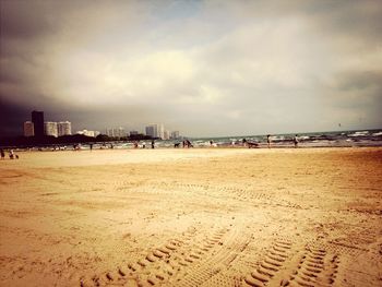 Scenic view of beach against cloudy sky