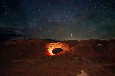 Scenic view of illuminated rock formation against sky at night