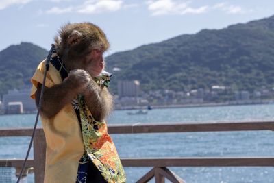 Man standing by railing against sky